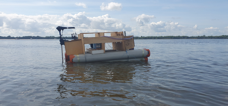 A fotografia mostra um barco no rio Tocantins. Ele está centralizado na imagem e de lado para o observador, indo à direita. Ao fundo, o céu está claro.